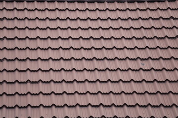 House roof with steel roofing sheet. Traditional metal shingle tiles. Gray modular tile effect roof panel. Profiled metallic corrugated pantile as clay or concrete slate. Building's covering