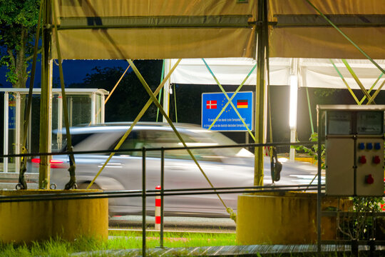 The border crossing between Denmark and Germany in Padborg with view from the german side at evening with a passing car