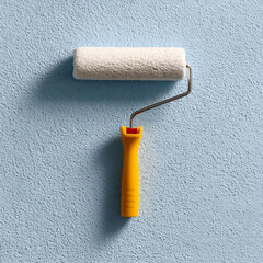 Obraz premium Paint Roller with Yellow Handle on a Textured Blue Wall for Home Improvement and DIY Projects