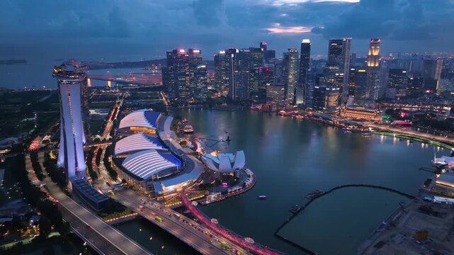 Real time aerial video of Sunset in Singapore City Skyline. Flying Towards Marina Bay Sands and Gardens In Singapore. View of modern hotels and financial buildings. Travel landmark, tourist attraction
