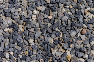 Granite gravel surface in natural gray tones, photographed up close as a textured stony background.