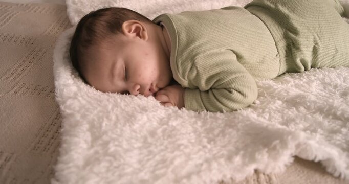 After being placed on plush white blanket infant breathing softly with chest rising to rest quietly