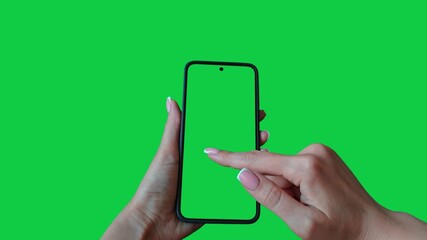 Young woman hand touch smartphone with green screen on green background. Phone in a female hand. Scrolling and swiping on a green phone screen. Template for scrolling through a feed in social network - Powered by Adobe