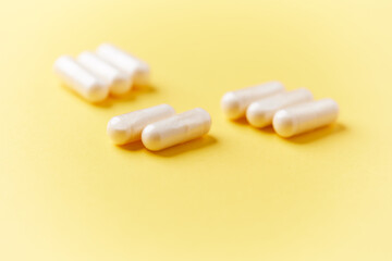 Collagen capsules. Bright paper background. Soft focus. Close up. Copy space.	