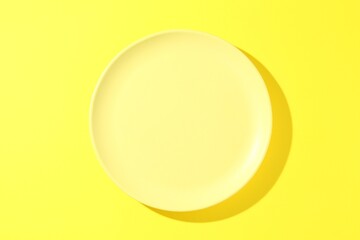 One stylish plate on yellow background, top view