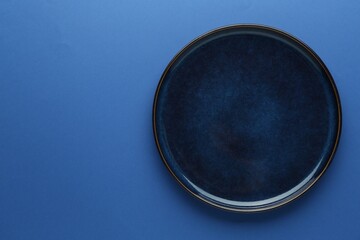 One stylish plate on blue background, top view. Space for text