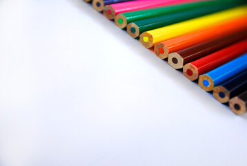 Bottom perspective view of colored pencils, arranged in order, diagonally, right side, on a white background