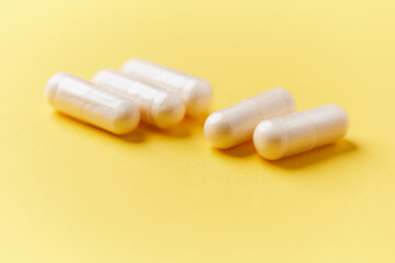 Collagen capsules. Bright paper background. Soft focus. Close up. Copy space.	