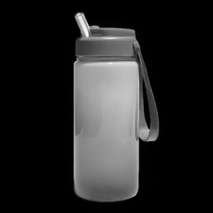 A gray reusable water bottle with a straw and handle sits against a dark background in studio shot