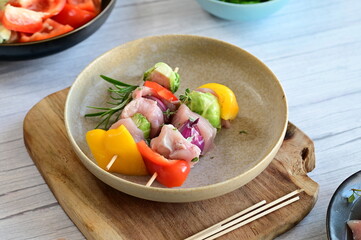 Close-up of raw chicken skewers with colorful vegetables, prepared for baking. A vibrant and fresh composition showcasing homemade cooking