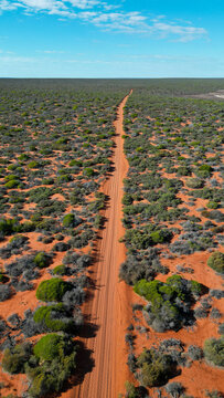 A car driving through the red soil of Australia, seen from above