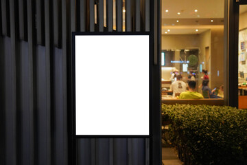 Clear street signage board placed by an outdoor dinning area of a restaurant at night