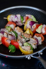 Grilled Chicken Skewer with Vegetables on Frying Pan at Home Kitchen with Induction Stove