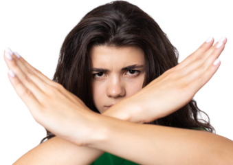 Portrait of a serious young woman showing stop gesture with her palm over white background