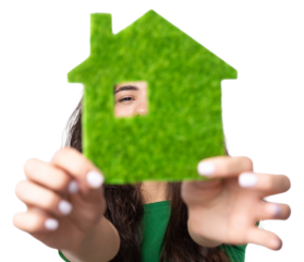 Happy house buyer. A young girl holds a model of a green house in her hands. The concept of green energy, ecology.