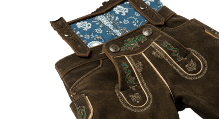 A close up shot of lederhosen with intricate embroidery and a patterned blue fabric panel detail on transparent background