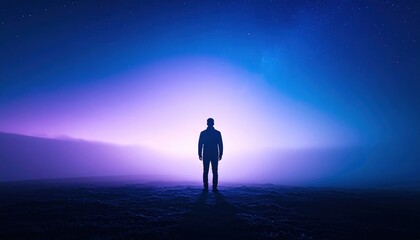 Obraz premium Solitary Figure in Mystical Light: A lone silhouette stands against a vibrant gradient of blue and purple light in a mysterious, foggy landscape.