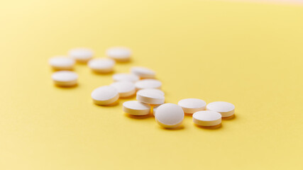 Vitamin B1 (Thiamine, also known as thiamin) tablets on bright paper background. Soft focus. Close up. Copy space	