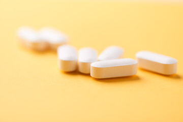 Magnesium tablets on bright paper background. Soft focus. Close up. Copy space	
