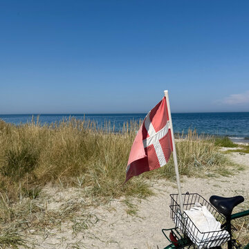 Danish flag on the back of a bicycle at the beach on a summer day, Nordby, Samsoe, Jutland, Denmark