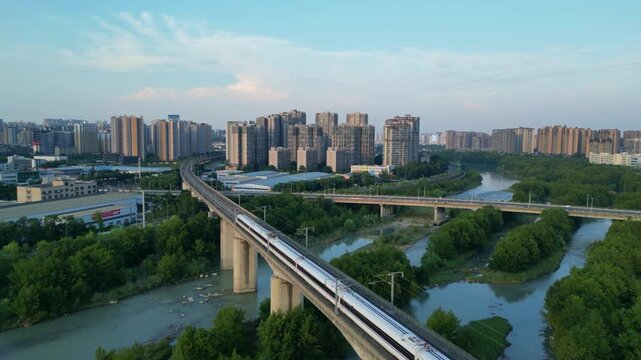 China's modern high-speed trains travel through elevated tracks in cities filled with residential buildings.