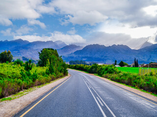 Fototapeta premium Winding road through rural Villiersdorp village with Riviersonderend Mountains backdrop, South Africa