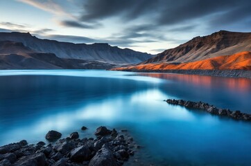 Stunning landscape at dawn by the tranquil lake surrounded by majestic mountains in a remote region