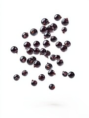 Falling black currant berries floating in the air isolated on white background