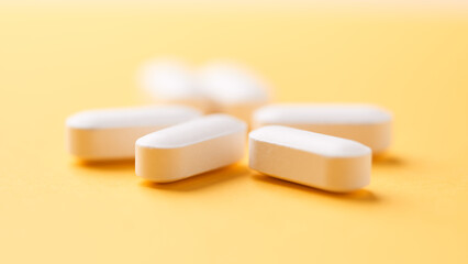 Magnesium tablets on bright paper background. Soft focus. Close up. Copy space	