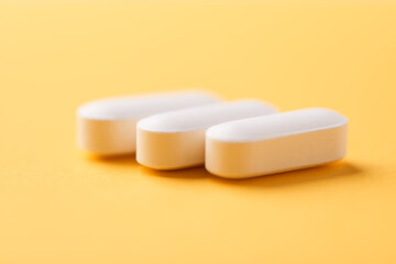 Magnesium tablets on bright paper background. Soft focus. Close up. Copy space	