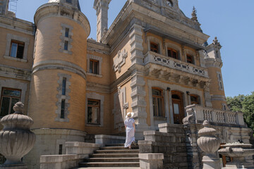 Obraz premium A woman stands on the steps of a large building, looking out over the courtyard