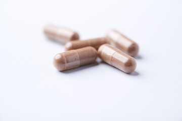 Ashwagandha (Withania somnifera) capsules. Concept for a healthy dietary supplementation. Bright paper background. Close up. Copy space.