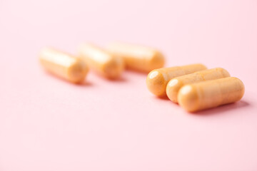 Vitamin B complex capsules on bright paper background. Soft focus. Close up. Copy space.