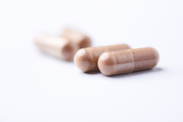 Ashwagandha (Withania somnifera) capsules. Concept for a healthy dietary supplementation. Bright paper background. Close up. Copy space.