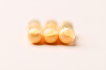 Coenzyme Q10 capsules. Antioxidants. Concept for a healthy dietary supplementation. Bright paper background. Soft focus. Close up. Copy space.	