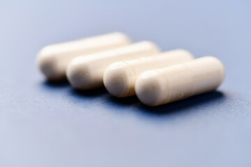 Arginine capsules on bright background. Soft focus. Close up. Copy space.	