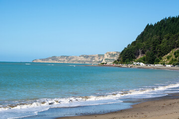 Serene Beach with Cliffs and Clear Blue Sky