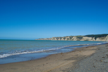 Serene Beach with Cliffs and Clear Blue Sky