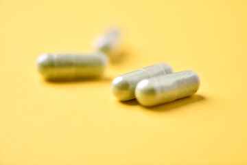 Barley grass capsules. Antioxidants. Concept for a healthy dietary supplementation. Bright background. Soft focus. Close up. Copy space.