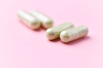 Barley grass capsules. Antioxidants. Concept for a healthy dietary supplementation. Bright background. Soft focus. Close up. Copy space.