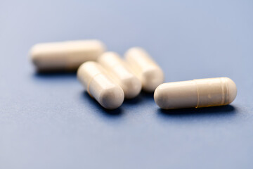 Arginine capsules on bright background. Soft focus. Close up. Copy space.