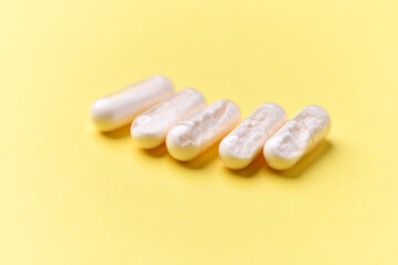 Coenzyme Q10 capsules. Antioxidants. Concept for a healthy dietary supplementation. Bright paper background. Soft focus. Close up. Copy space.	