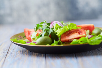 Healthy and tasty salad with tomatoes, olives, cucumber, and lettuce.	