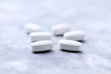 Amino acids tablets on wooden background. Soft focus. Close up