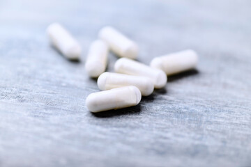 Beta-alanine capsules. Bodybuilding food supplements on wooden background. Soft focus. Close up. Copy space.	