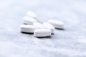 Amino acids tablets on wooden background. Soft focus. Close up	