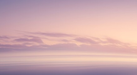 A serene view of a pastel sky with soft clouds and a gradient of light pink and lavender hues during sunset