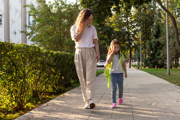 Obraz premium Mother and child walking on a sunny day in the park