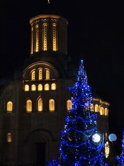 Facade of the Pyatnitskaya Church with festive lighting and a Christmas tree