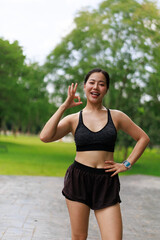 Fototapeta premium Young sportswoman gesturing ok sign after training in the park